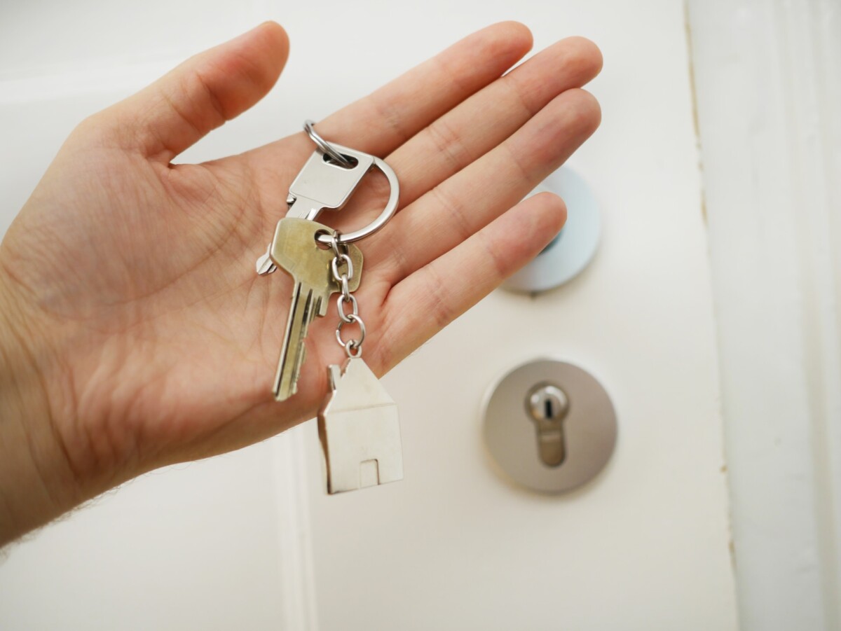a hand holding keys to a house